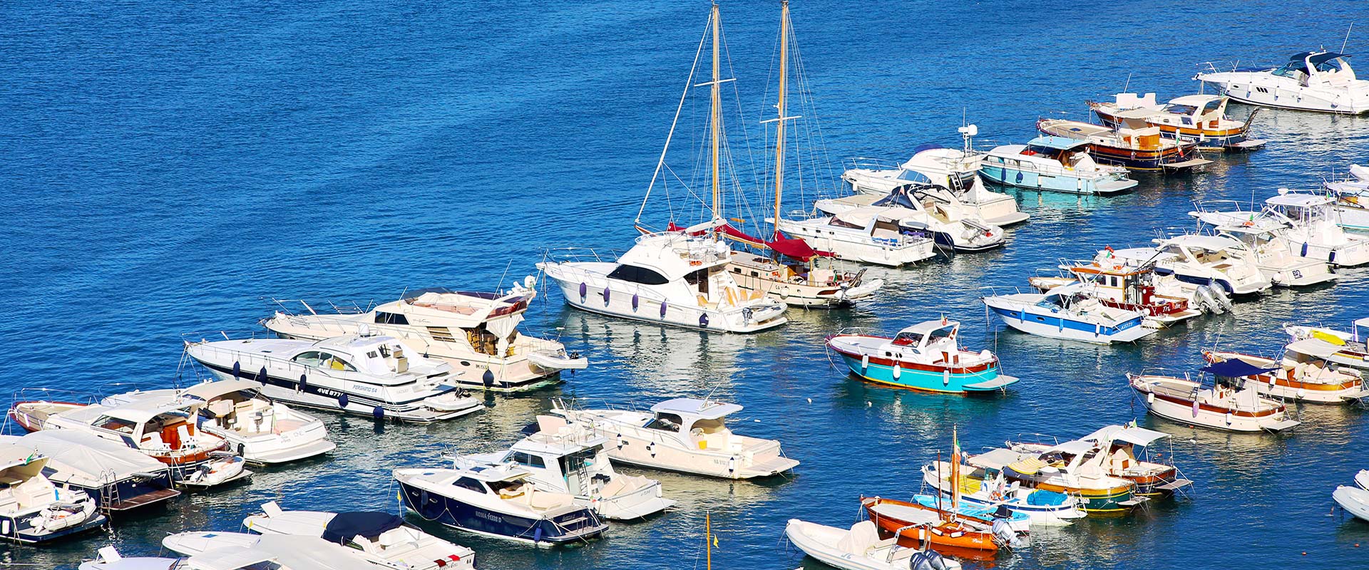 Yachts and of different sizes in blue waters.